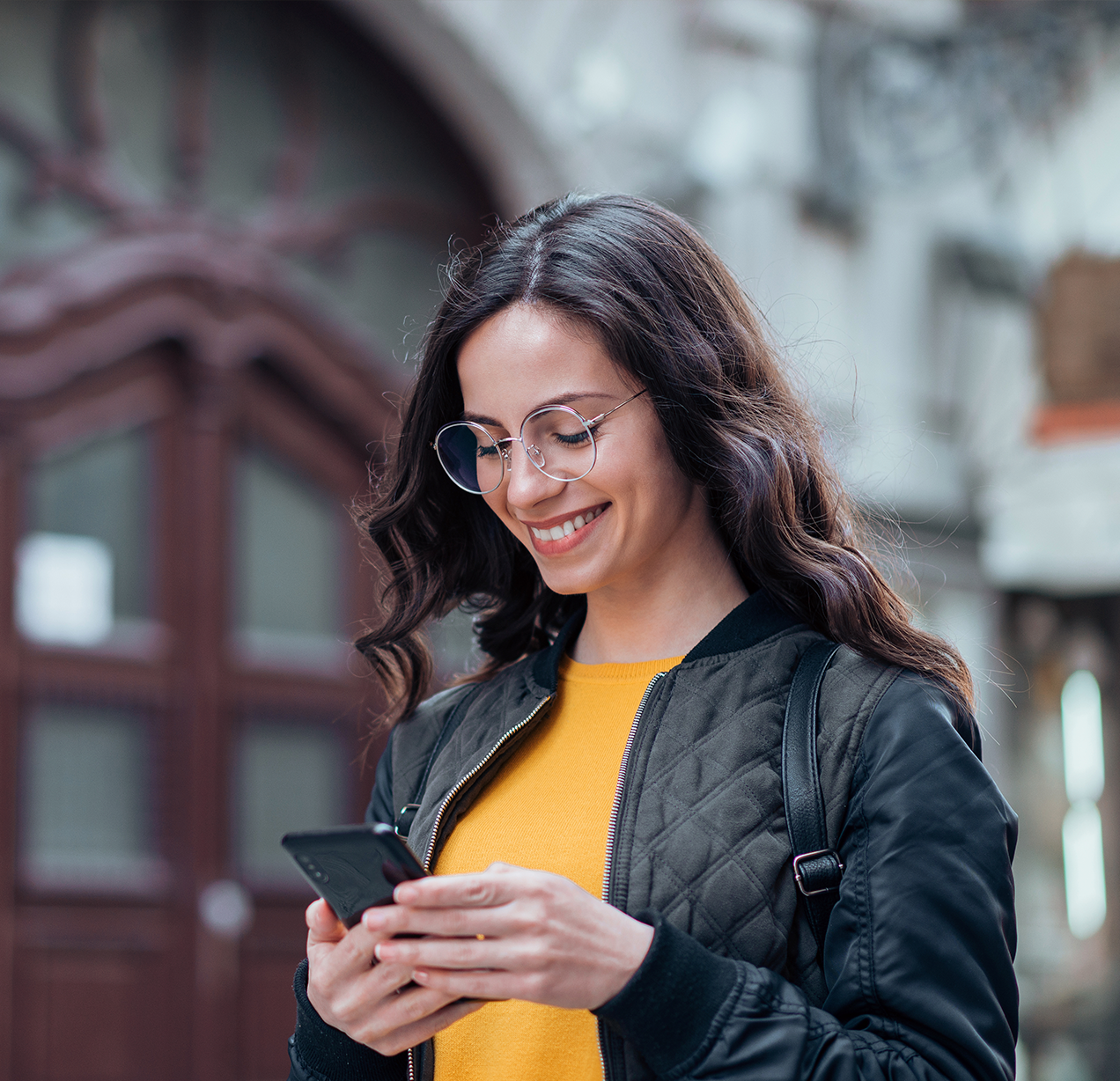 Mujer sonriendo mirando su celular