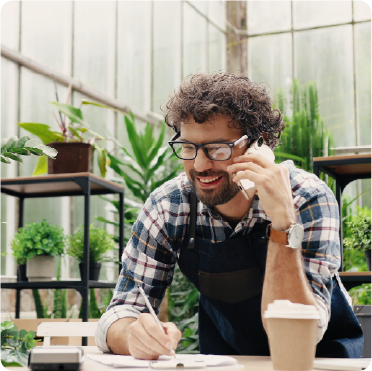 Emprendedor hablando por celular en su tienda de plantas