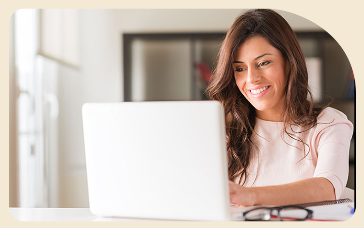 Mujer sonriendo frente a un computador