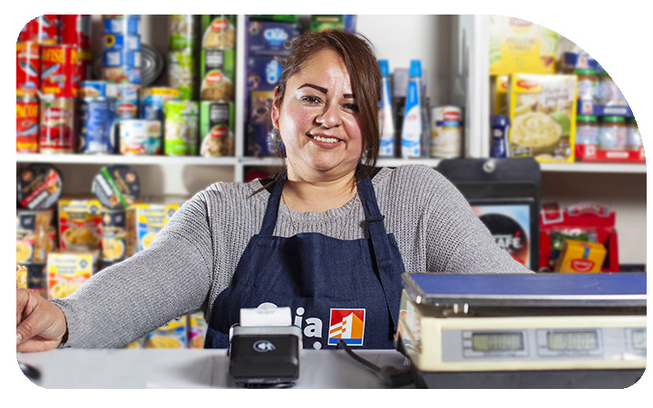Operadora CajaVecina sonriendo en su almacén
