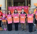 Participantes y mascotas de Corrida Techo posan con poleras de la actividad