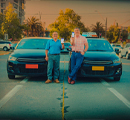 Dos hombres posando frentes a sus vehiculos colectivos