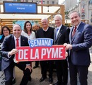 Autoridades participan en la Semana de la Pyme con letrero del evento.