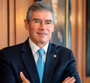 Mario Farren con traje formal en entorno institucional