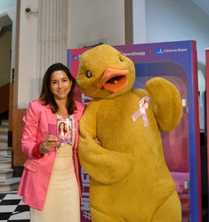 Mujer junto al Pato de BancoEstado en campaña de prevención del cáncer de mama.