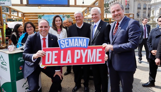 Autoridades participan en la Semana de la Pyme con letrero del evento.